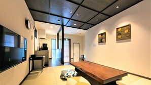 Ein modernes Interieur mit einem langen Holztisch, Tatami-Matten und minimalistischem Design.