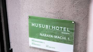 A sign for Musubi Hotel in Naraya-Machi, including the address and contact number.