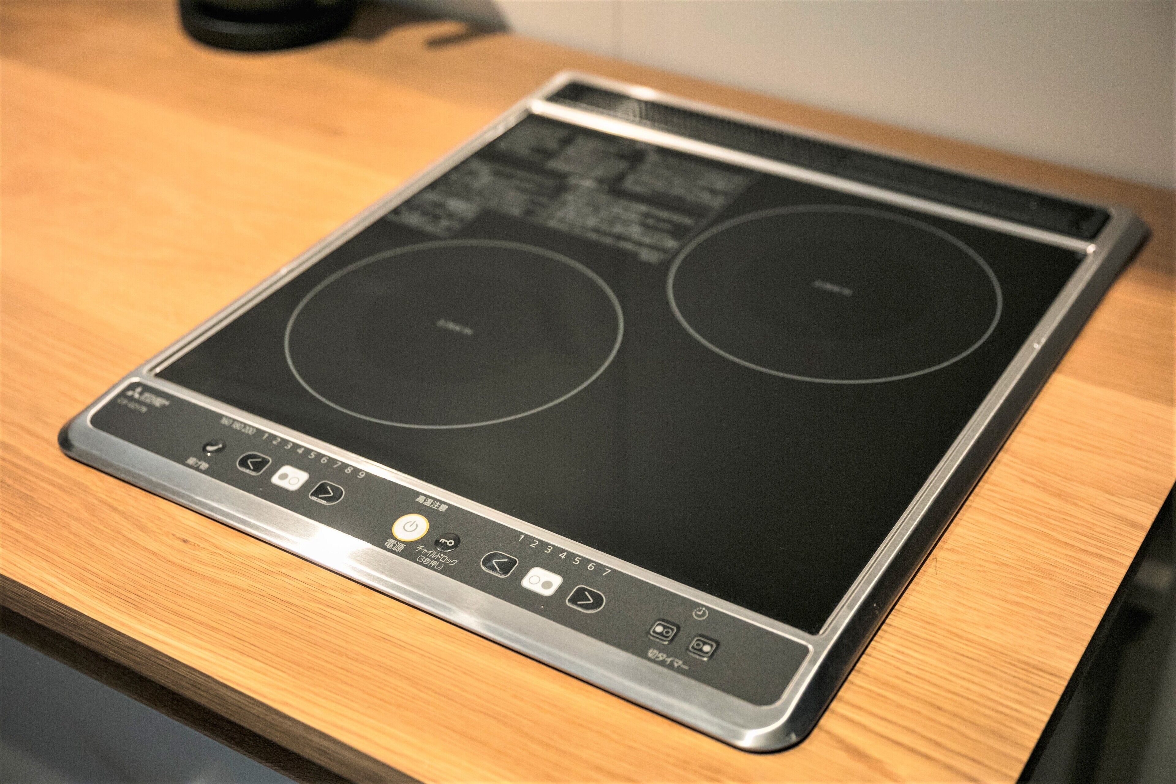 Une cuisine équipée d’une plaque de cuisson à induction intégrée et d’un panneau de commande doté de divers boutons et d’un écran numérique.
