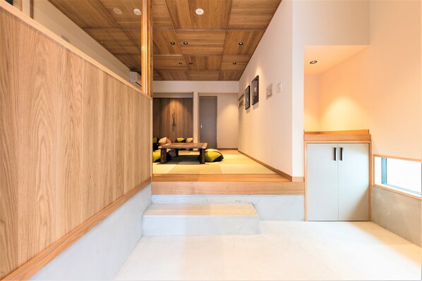 Un intérieur moderne avec un escalier en bois, un coin salon et une petite cuisine.