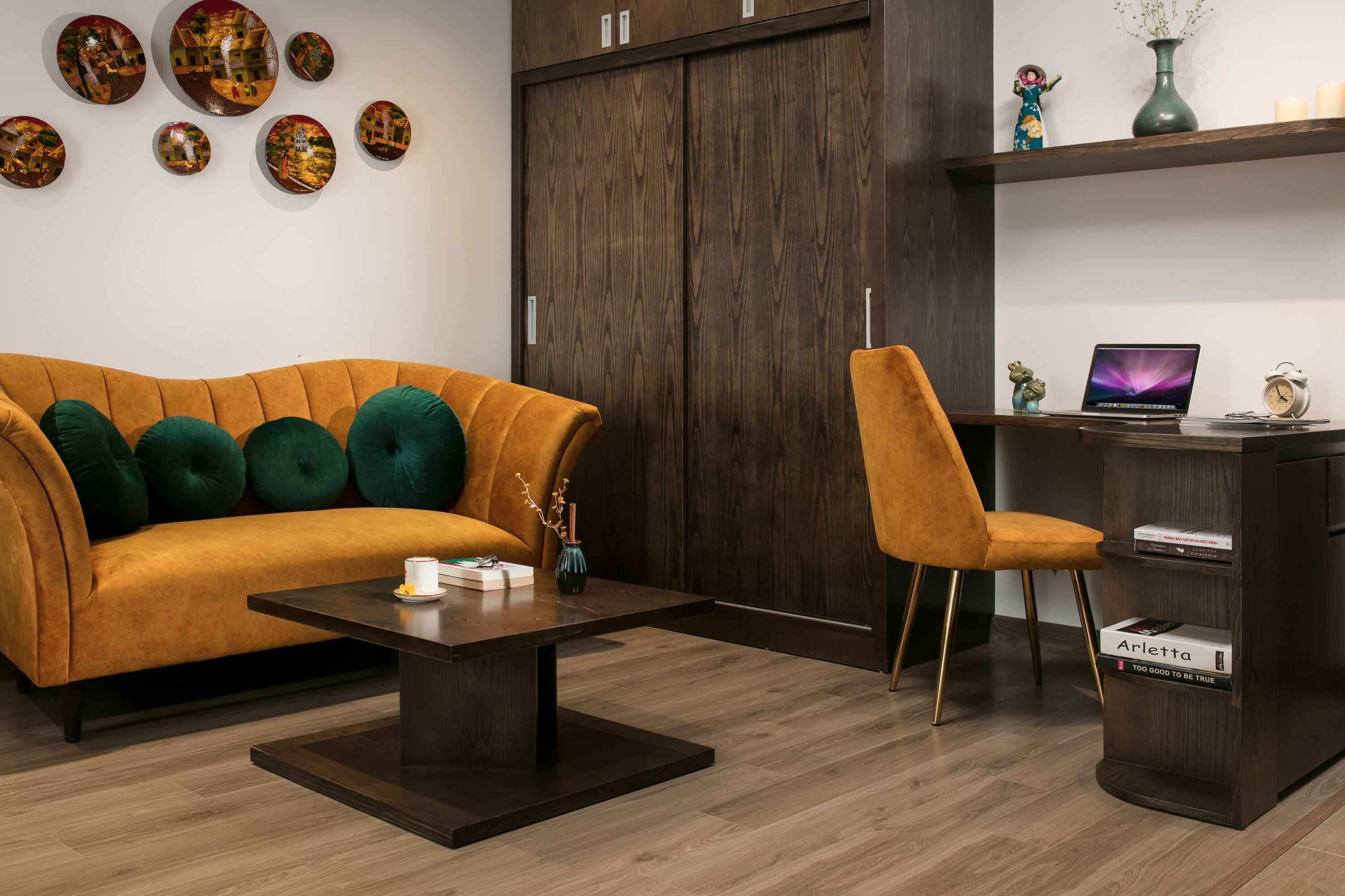 Een moderne woonkamer met een bank, salontafel en bureau met een laptop.