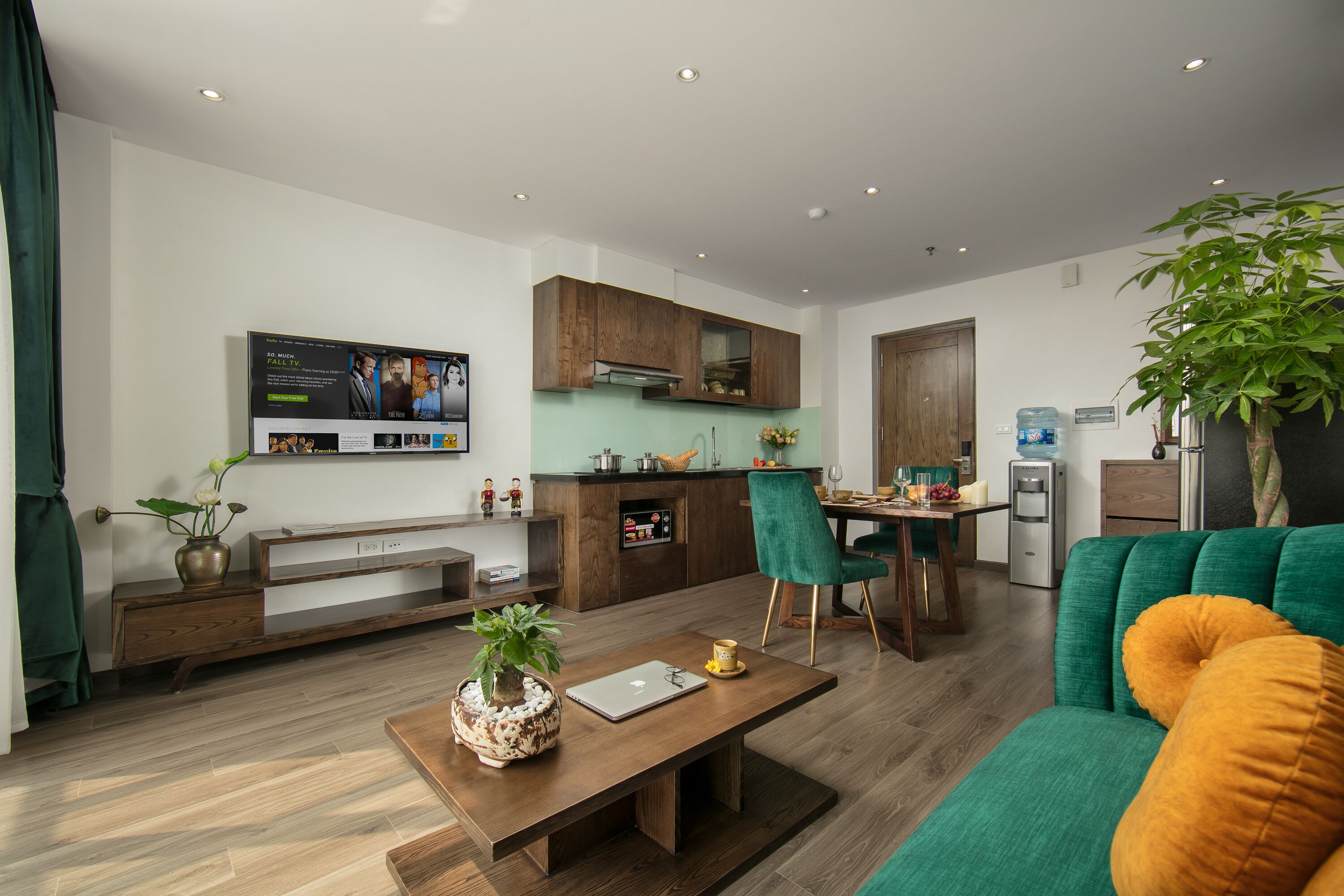 A modern living room with a sofa, a coffee table, and a TV mounted on the wall.