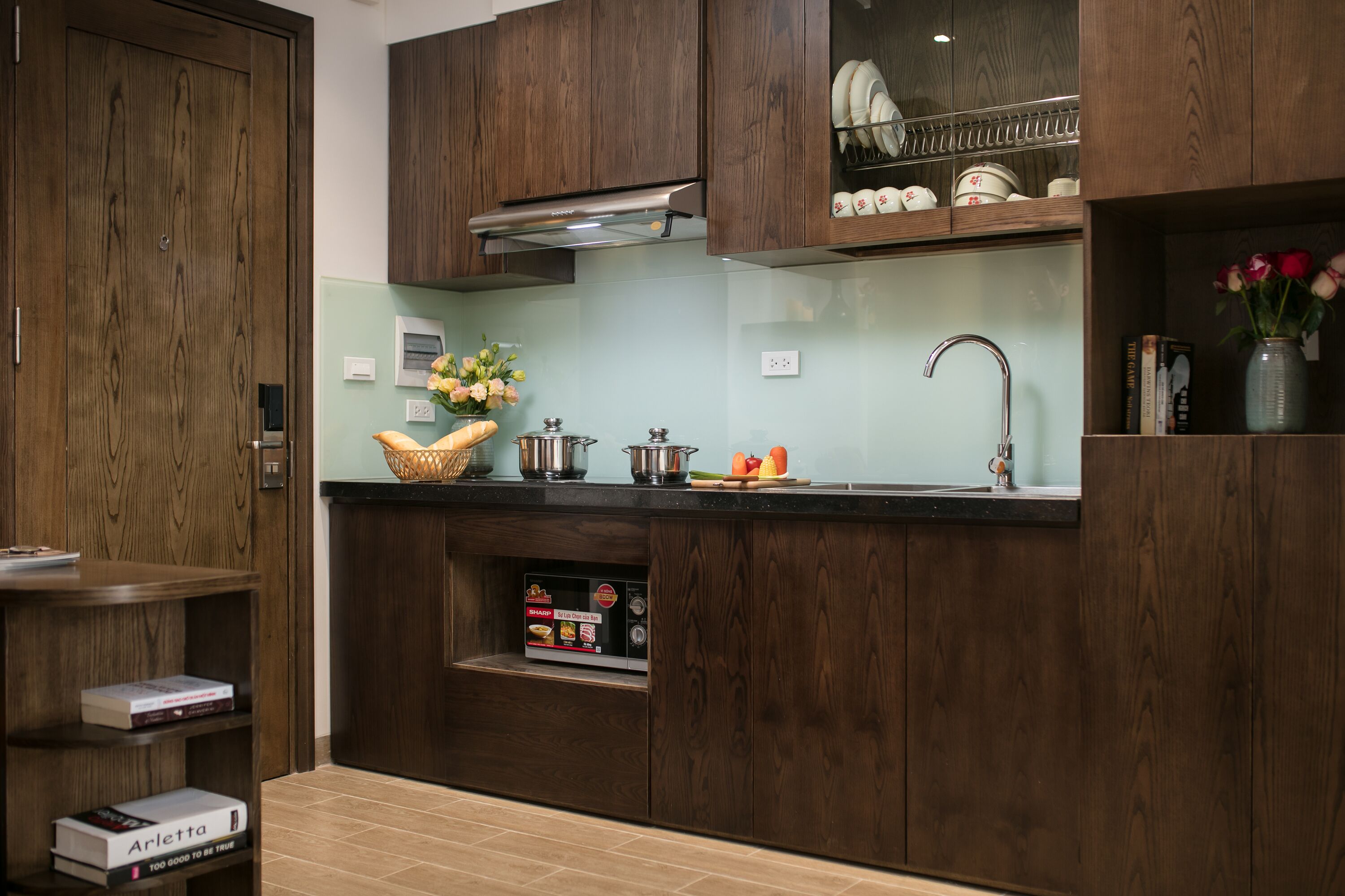 Una cocina moderna con armarios de madera, horno empotrado y un lavamanos.