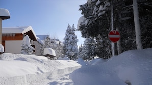 A snow-covered road with a no-entry sign, buildings with snow-covered roofs, and snow-laden trees. - Hotel Iris (Roccaraso)