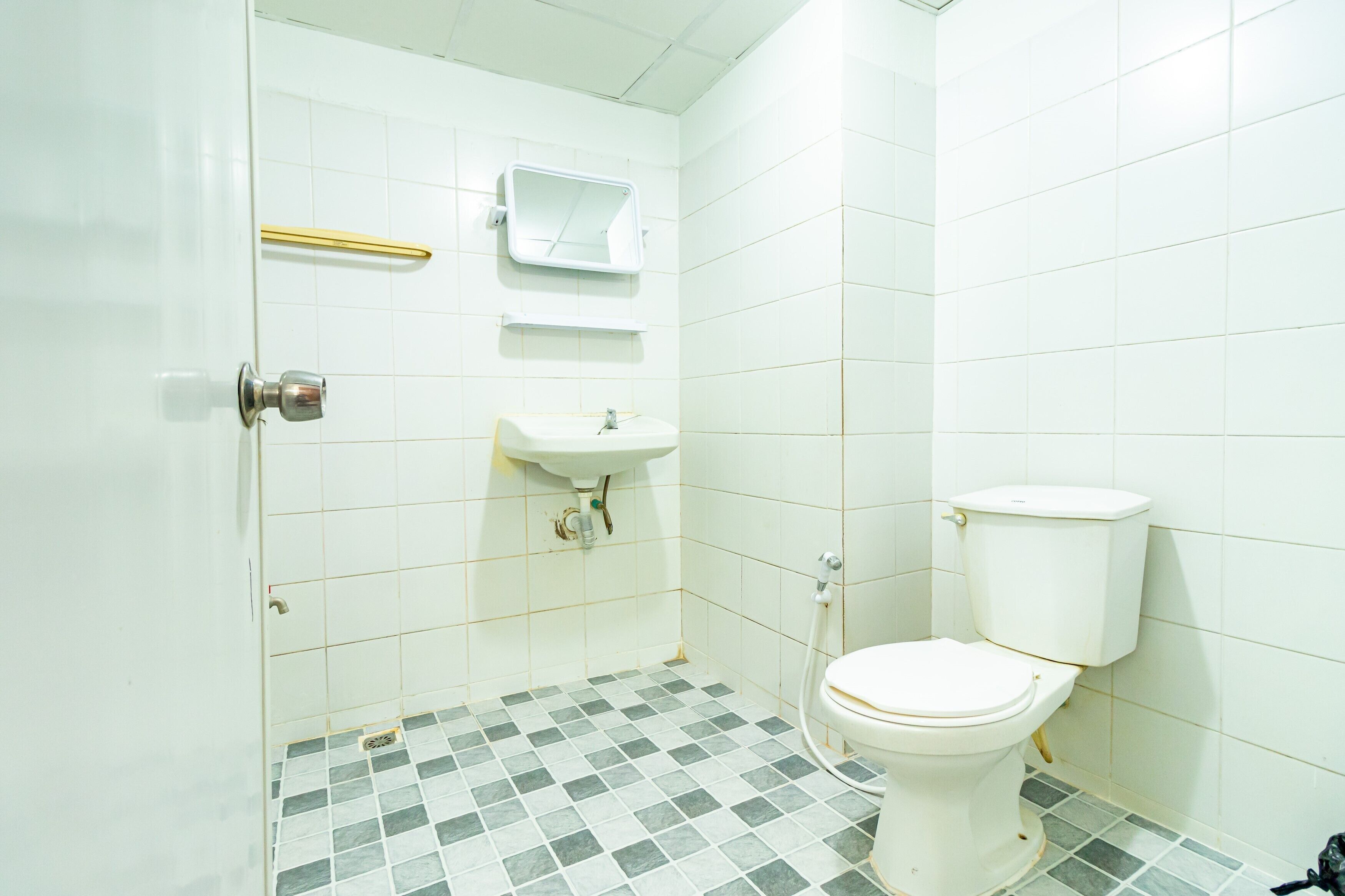 Un baño con inodoro, lavamanos y espejo.