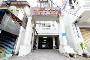 The entrance to Boonchai Mansion with a sign in Thai, a satellite dish, and a gated entrance. - Boonchai Mansion (Hat Yai)