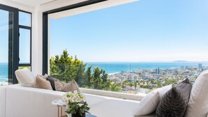 A modern living room with a large window overlooking a cityscape and the sea. - Coeur De Lion 5 (Cape Town)