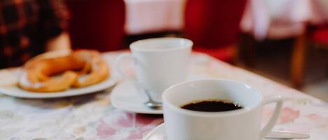 Una mesa con una taza de café y un plato de pasteles.