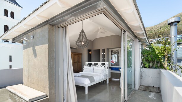 A balcony with a bed, a shower, and a view of a mountain. - Pine Road 26 (Cape Town)