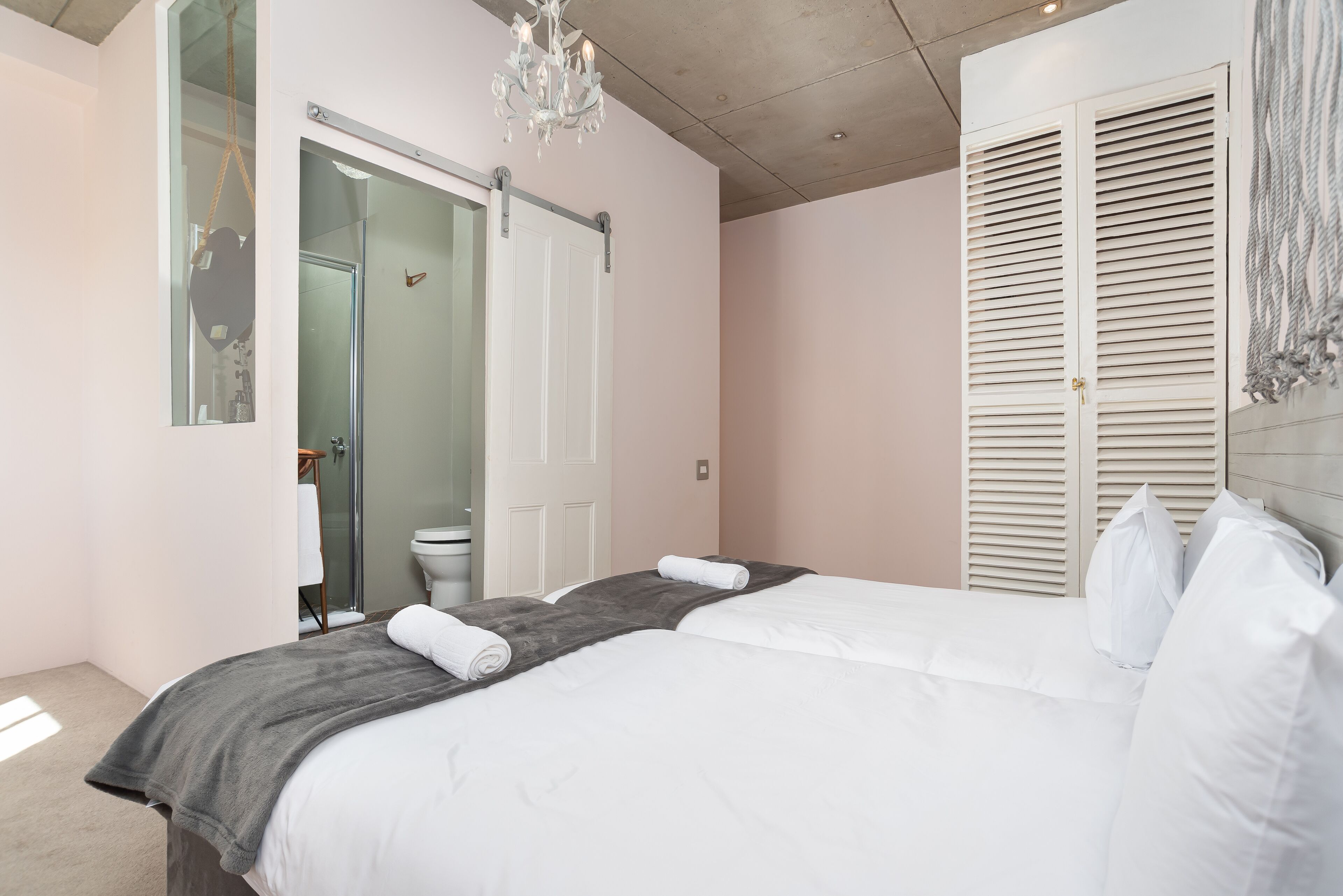 A bedroom with a bed, a shower, and a toilet.