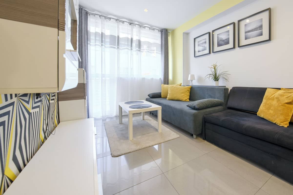 Una sala de estar moderna con un sofá, una mesa de centro y un televisor.
