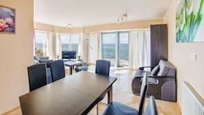 A modern living room with a dining area, large windows, and a view of the sea. - Sun & Snow Wechta - Promenada Gwiazd (Miedzyzdroje)