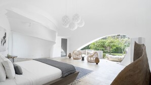 Un dormitorio moderno con una cama grande, vistas al exterior y un diseño de techo original.