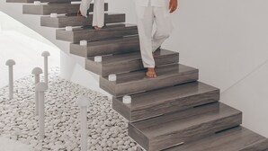 Una escalera moderna con un diseño minimalista, mostrando a una mujer y un hombre tomados de la mano.