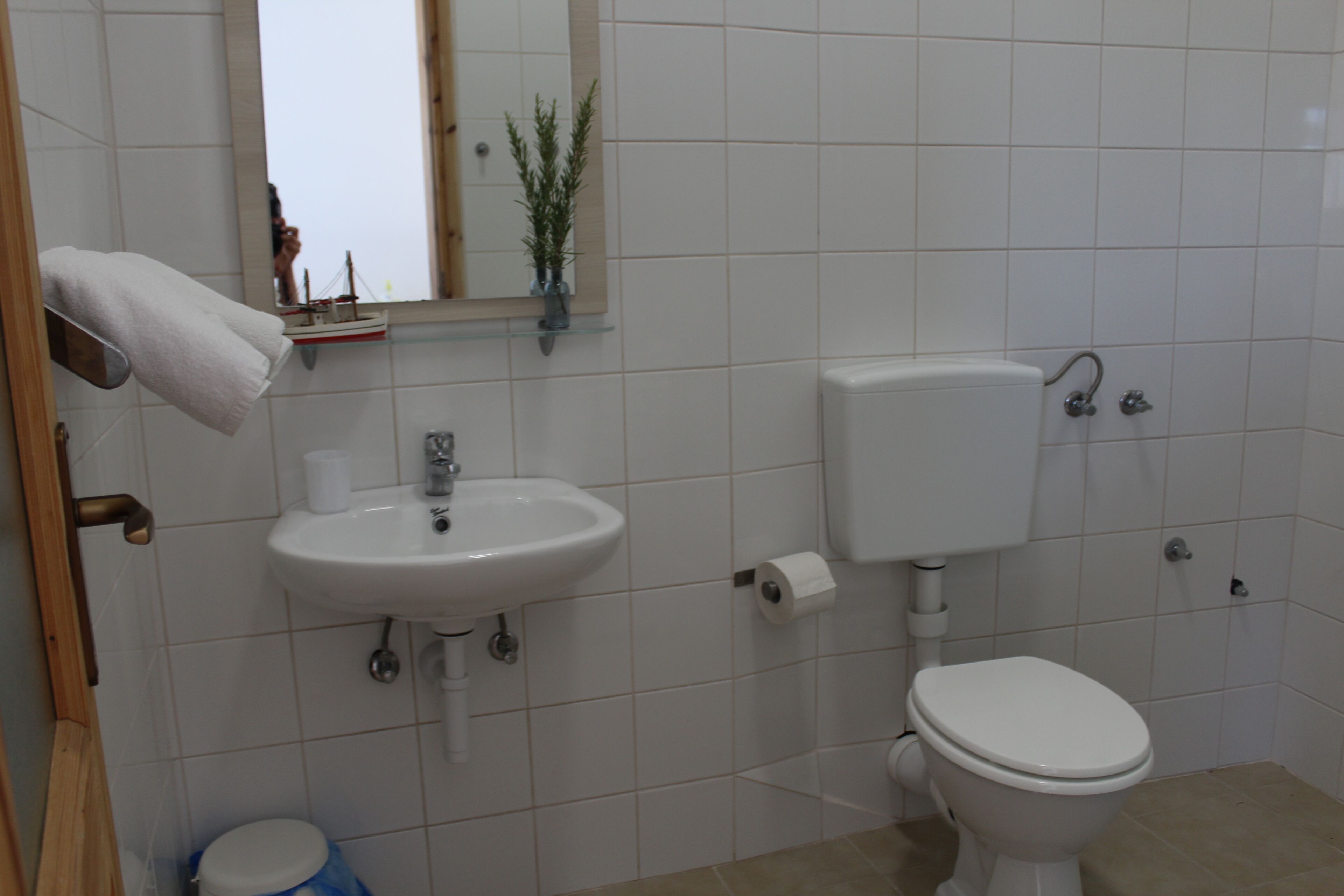 Une salle de bain avec un lavabo, des toilettes et un miroir.