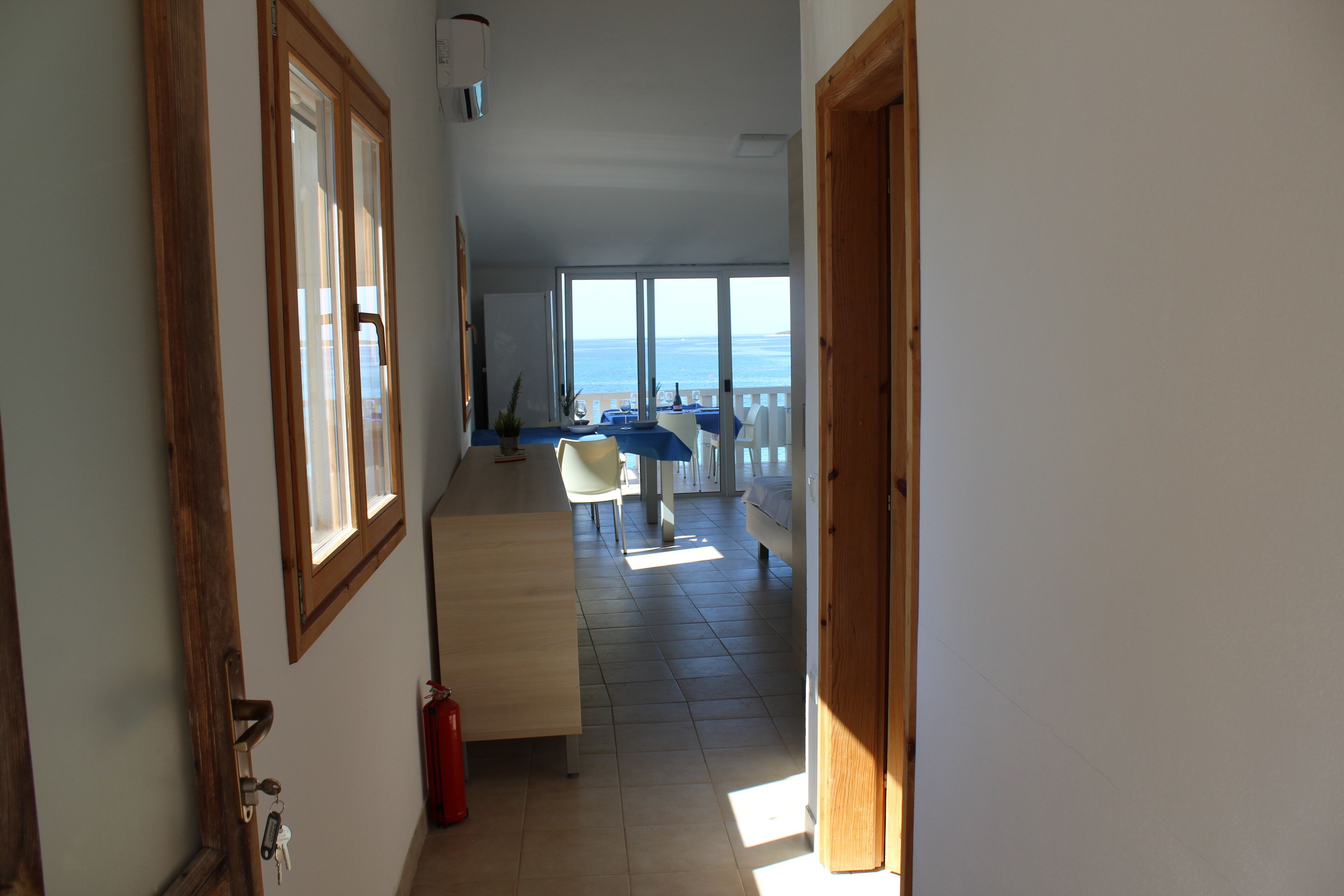 Un pasillo que da a un balcón con vista al mar.