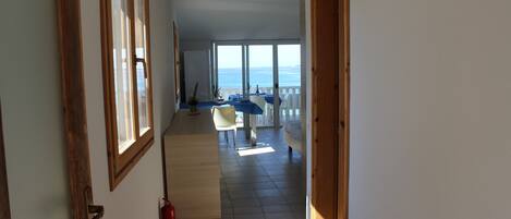 Un pasillo que da a un balcón con vista al mar.