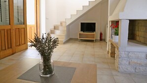 A modern living room with a staircase, a fireplace, and a television. - Beach Villa Olivia (Lumbarda)