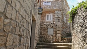 A stone building with a sign indicating it's for rent. - Beach Villa Olivia (Lumbarda)