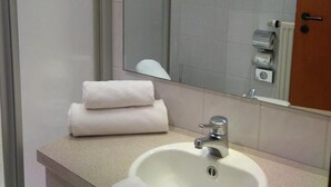 A bathroom with a sink, mirror, and towel rack. - Hotel Loewensteiner Hof Haus am Neuplatz (Wertheim)