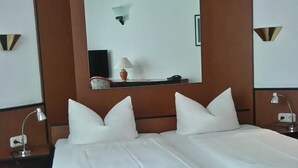 A double bed with white linens, a large mirror above it, and two bedside lamps. - Hotel Loewensteiner Hof Haus am Neuplatz (Wertheim)