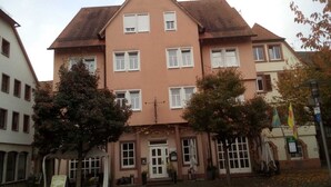 A multi-story building with a central entrance, large windows, and a traditional architectural style. - Hotel Loewensteiner Hof Haus am Neuplatz (Wertheim)