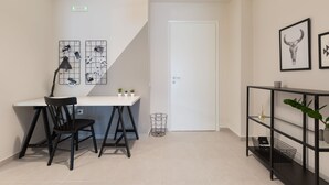Quarto moderno com escrivaninha, cadeira e estantes.