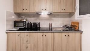 Cozinha com armários de madeira, micro-ondas, torradeira e chaleira.