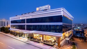 Ein Premier Best Western Hotel mit moderner Glasfassade, Außenbereich mit Sitzgelegenheiten und beleuchteter Beschilderung.