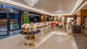 Eine geräumige Lobby mit Empfangstresen, Sitzgelegenheiten und einem Kronleuchter.