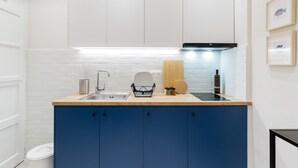 A modern kitchen with white cabinets, a blue countertop, and a stainless steel sink. - UPSTREET Acropolis Heart Apartments (Athens)