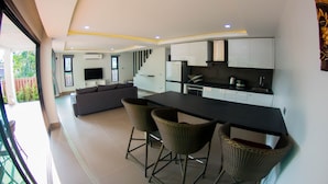 Una cocina moderna con comedor, armarios empotrados y un amplio ventanal.