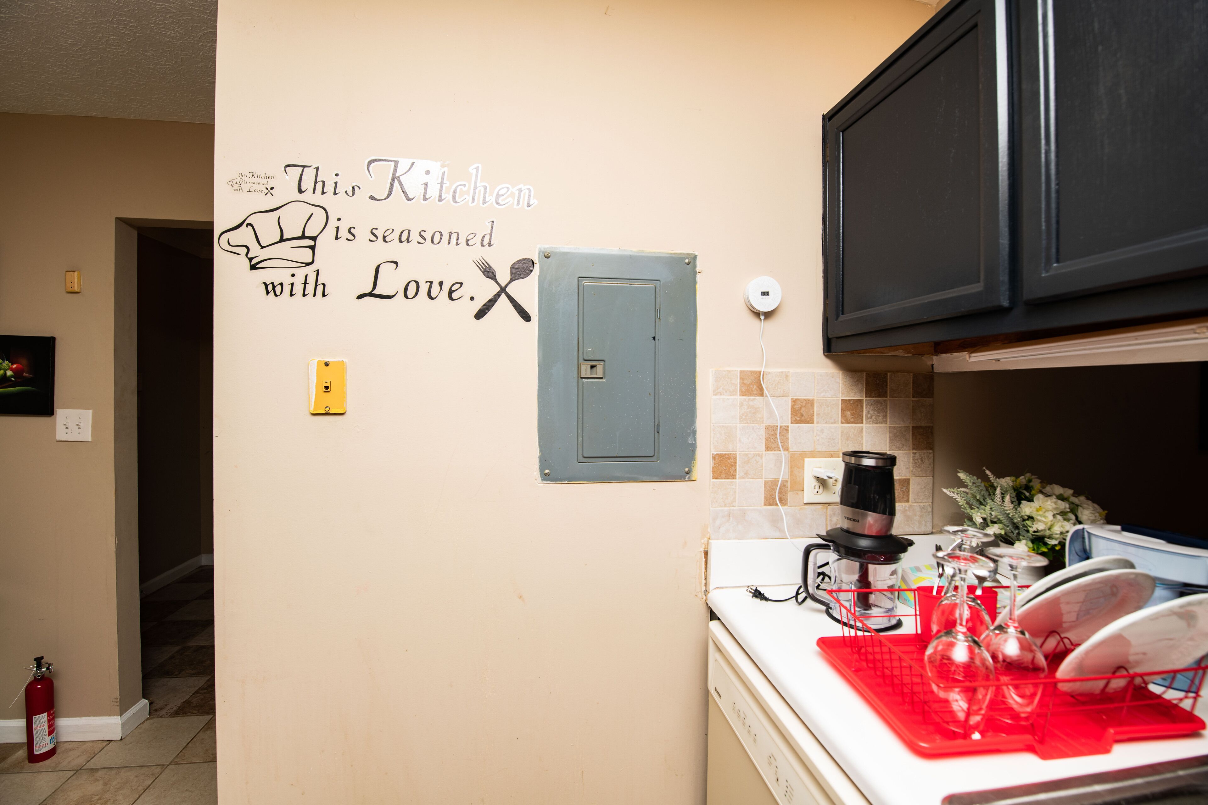 A kitchen with a wall decal stating 'This Kitchen is seasoned with Love.'