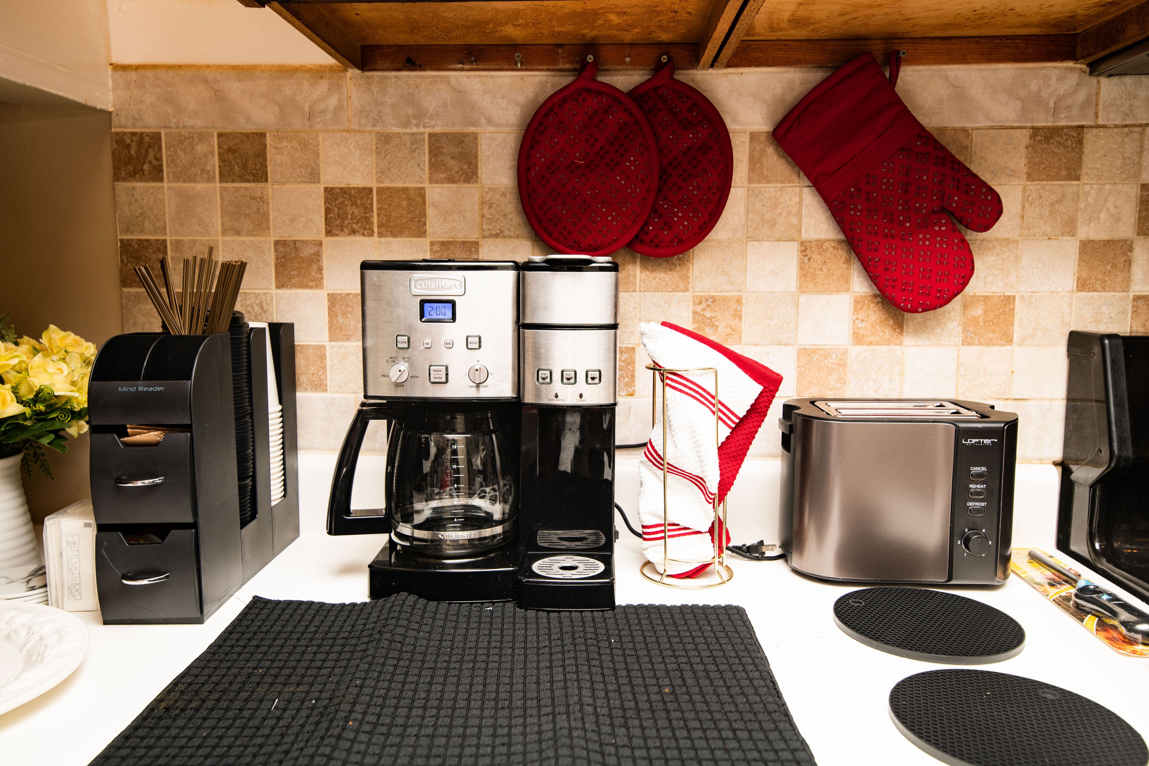 A kitchenette with a coffee maker, toaster, and a microwave.