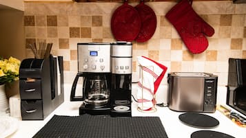 A kitchenette with a coffee maker, toaster, and a microwave.