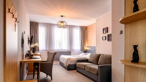 Une chambre d’hôtel moderne équipée d’un bureau, d’une chaise, d’un canapé et d’un lit.