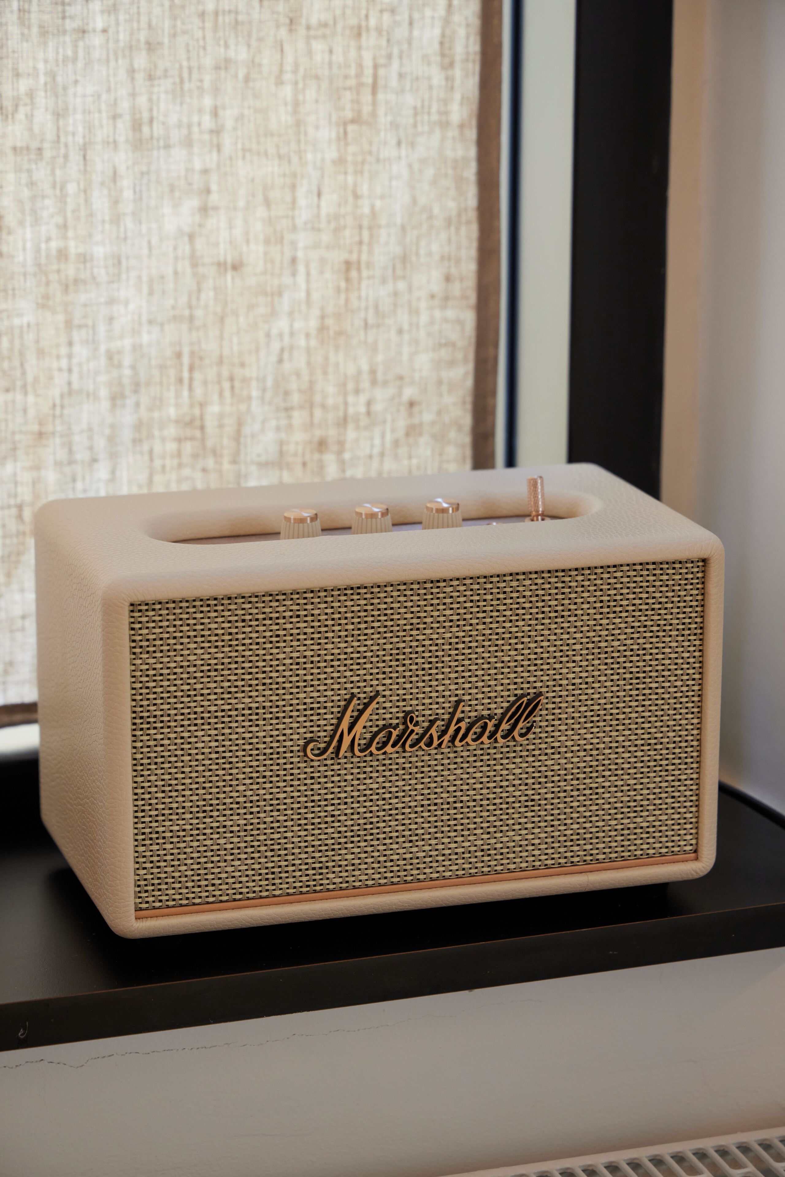 Un altavoz Marshall sobre una superficie negra.