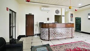 A reception area with a patterned counter, a reception desk, a door, and a tiled floor. - Hotel Dior Near Jal Mahal, Jaipur (Jaipur)