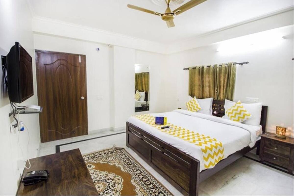 A bedroom with a bed, bedside table, nightstand, and a ceiling fan.