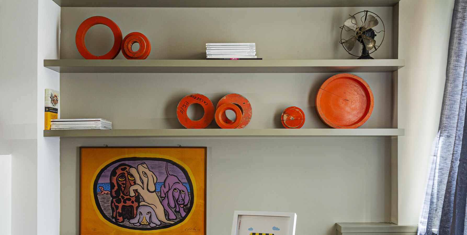A room with three shelves displaying various items.
