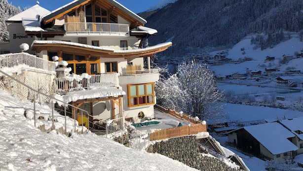 A multi-story hotel with a balcony and a ski lift. - Hotel Garni Bergwelt (See)
