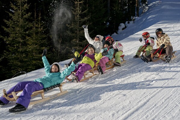 A group of people sledding down a snowy slope.