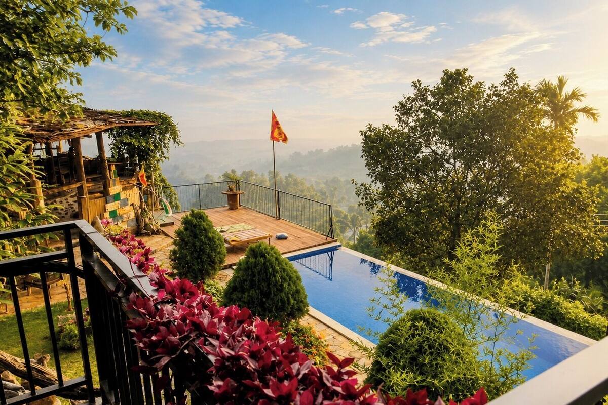 Une piscine dotée d’une terrasse en bois, entourée d’une végétation luxuriante et d’un drapeau.