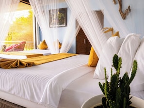 A bedroom with a bed, a window with a view, a cactus plant, and a wooden headboard. - Awesome Place Hotel (Ballaketuwa)