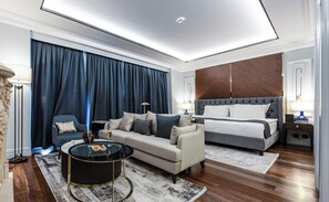 A modern hotel room with a sofa, a round coffee table, a bed, and a large window with curtains. - Xheko Imperial Hotel (Tirana)