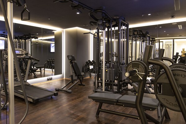A modern gym with various exercise equipment, including treadmills, dumbbells, and weight machines. - Xheko Imperial Hotel (Tirana)