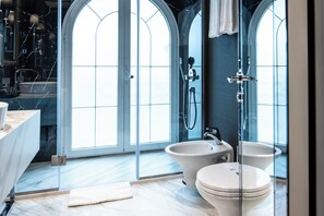 A modern bathroom with a glass-enclosed shower, two toilets, a sink, and a vanity. - Xheko Imperial Hotel (Tirana)