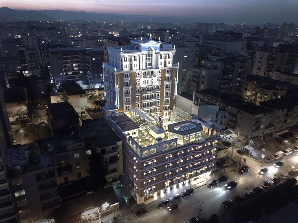 A multi-story hotel with a central courtyard, surrounded by other buildings. - Xheko Imperial Hotel (Tirana)