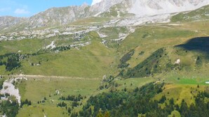 A mountainous landscape with a valley, a small settlement, and a prominent mountain range in the background. - 2-room apartment, ski-in/ski-out, pets allowed (Méribel)