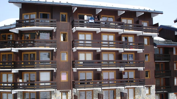 A multi-story hotel with balconies, large windows, and a stone facade. - 2-room apartment, ski-in/ski-out, pets allowed (Méribel)